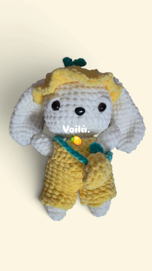 BrainRotPop handmade crochet bunny plushie wearing a yellow sun hat, yellow dungarees, and a small cross-body bag.