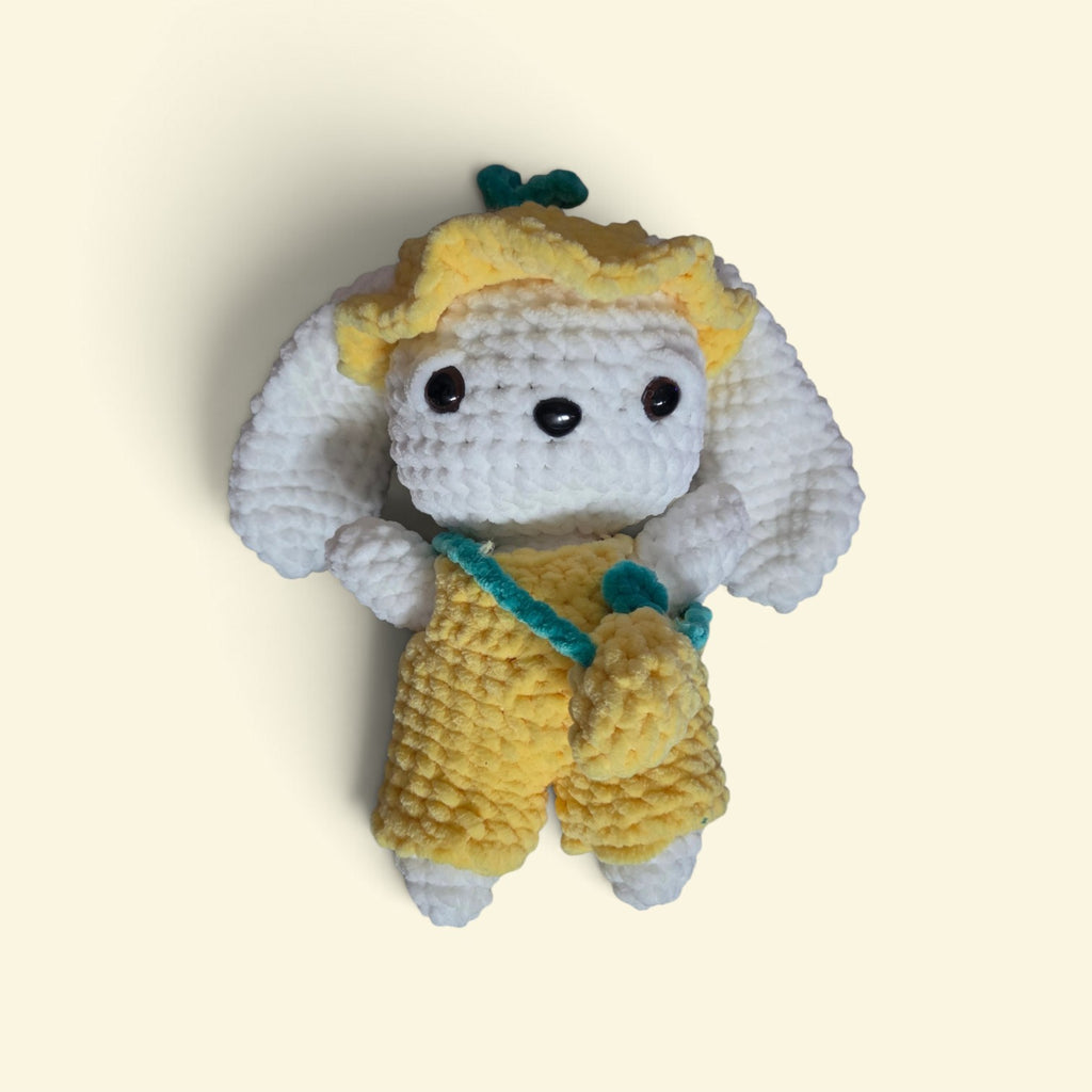 BrainRotPop handmade crochet bunny plushie wearing a yellow sun hat, yellow dungarees, and a teal cross-body bag.