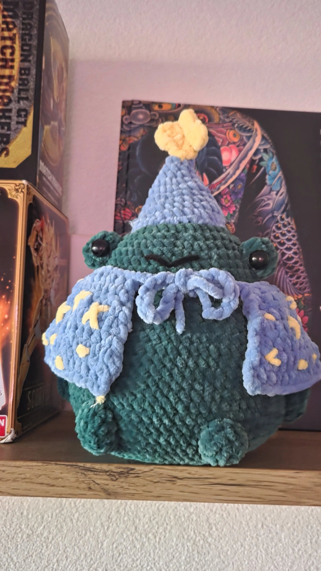 BrainRotPop handmade crochet wizard frog plushie in forest green velvet yarn with a periwinkle blue star-adorned cape.