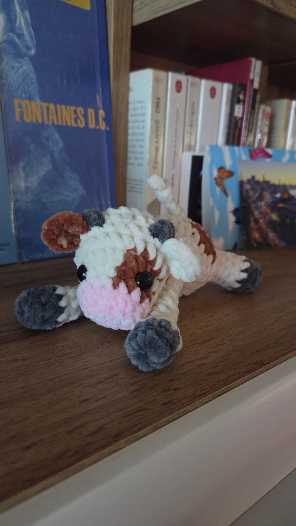 BrainRotPop handmade crochet cow plush toy made from soft cream, brown, and grey chenille yarn with a pink snout.