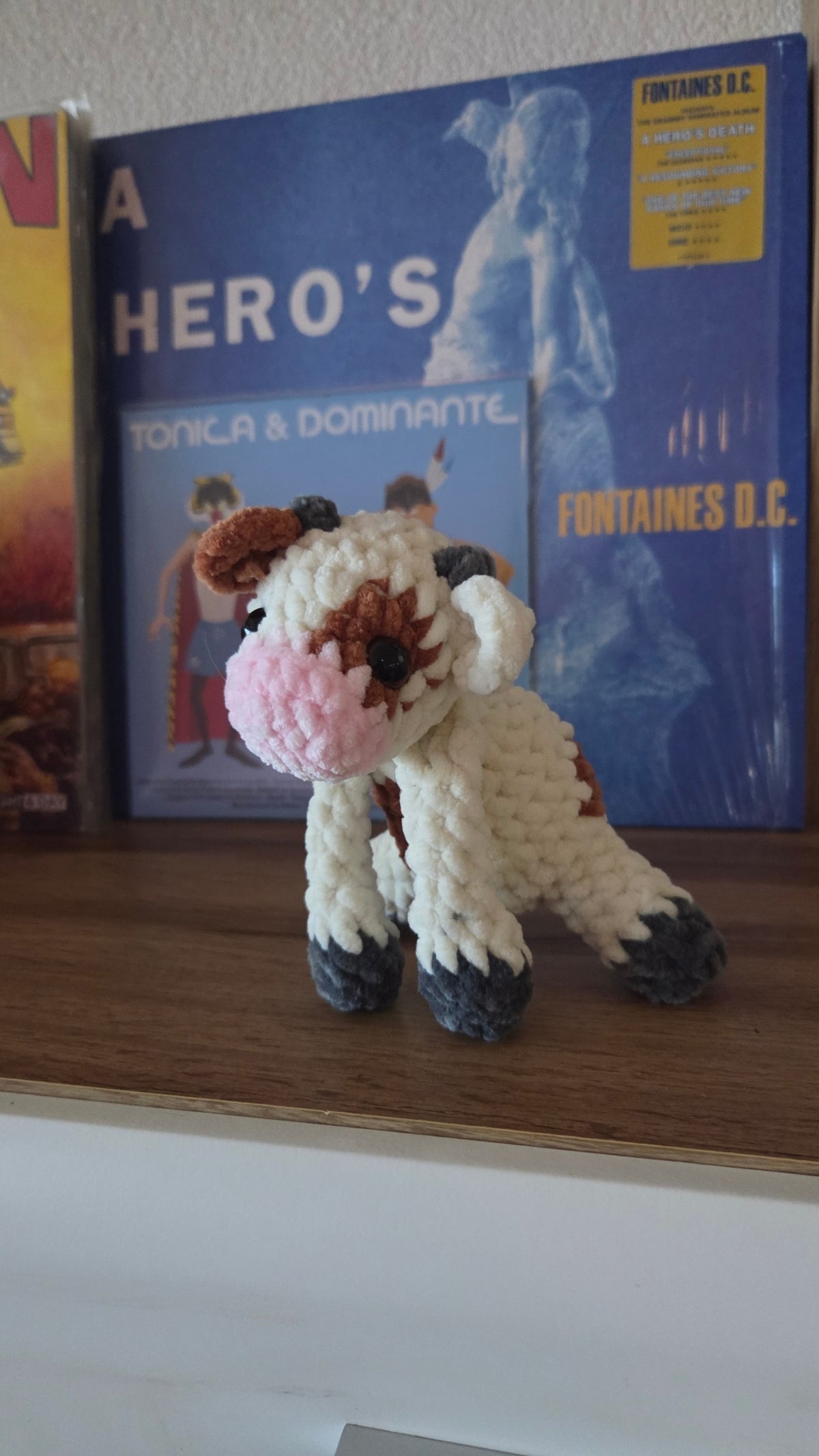 BrainRotPop handmade crochet cow plush toy made from soft cream, brown, and pink chunky chenille yarn.