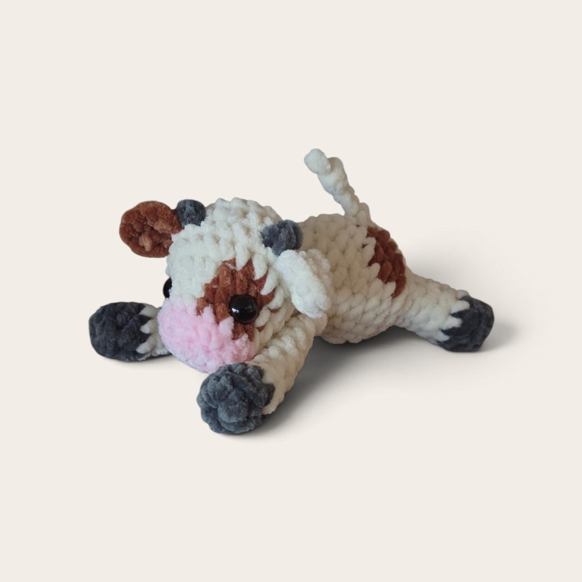 BrainRotPop handmade crochet cow plush toy in cream and brown chenille yarn with a soft pink snout.